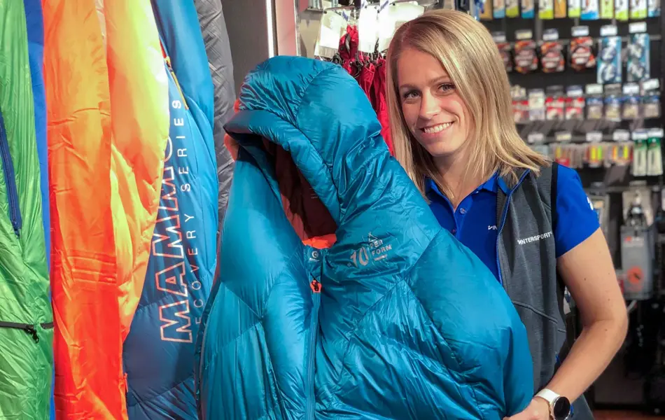 Ansatt på Intersport som holder soveposer