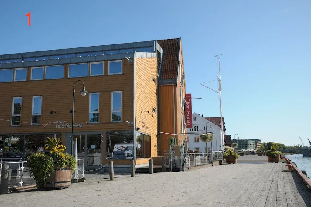 Fasaden til Thon Hotel Tønsberg Brygge med gule vegger og plassering på Brygga i Tønsberg sentrum.