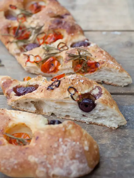 Italian bread made by an artisan baker topped with tomatoes, olives and herbs