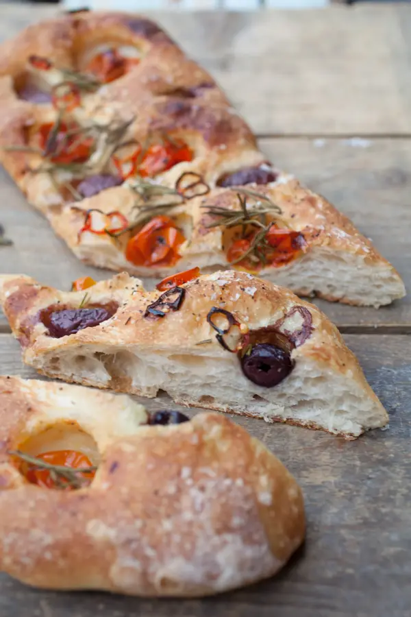 Italian bread made by an artisan baker topped with tomatoes, olives and herbs