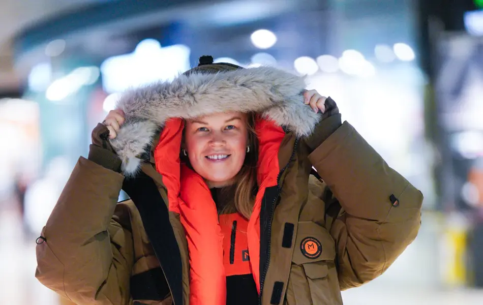 Jente med orangesekk og blådunjakke, og langrennski og slalåmski