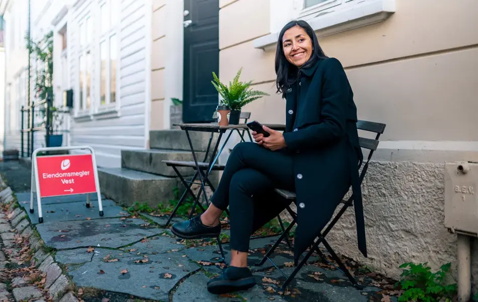visning på hus og dame som sitter på stol utenfor