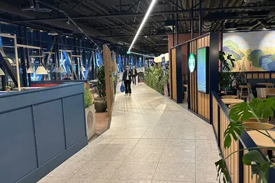 Folk går langs kafeene på den oppgraderte gangbroen på Vestkanten Storsenter