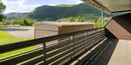 Flå leil H0104 med utsikt fra overbygget balkong mot bod, idrettsbane og fjell, Hallingtunet i Flå.