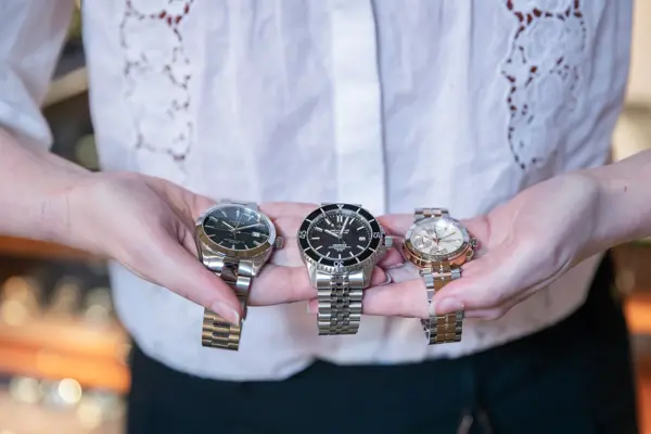 Hender som holder tre klokker