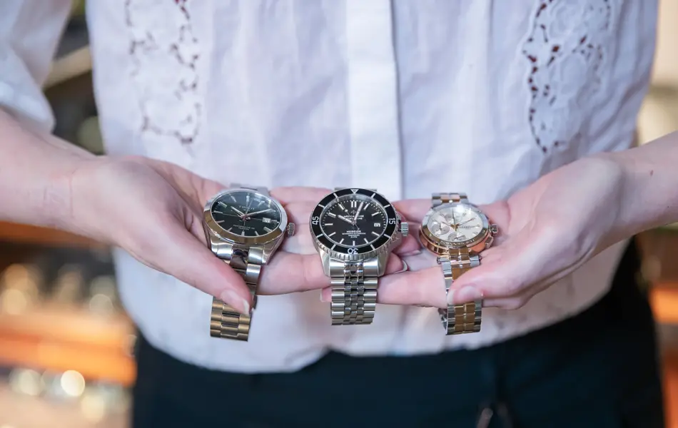 Hender som holder tre klokker