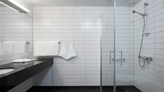 Bred vask og stort speil og dusj på standard room  på Thon Hotel Sandven