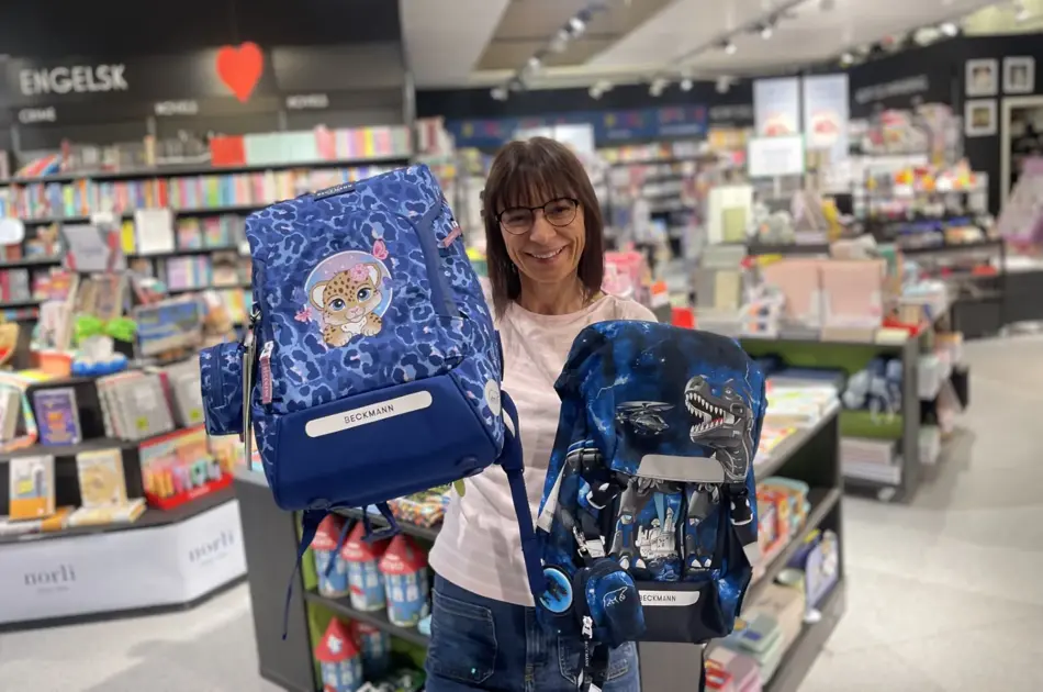 Ansatt som holder opp to ryggsekker