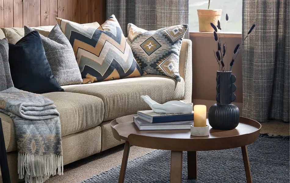 Sofagruppe med blå gardiner og trevegger i bakgrunn
