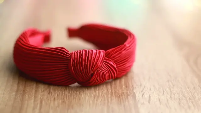 Red headband on wooden background. Selective focus.