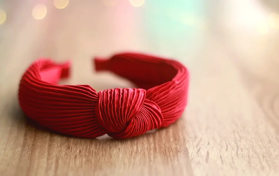 Red headband on wooden background. Selective focus.