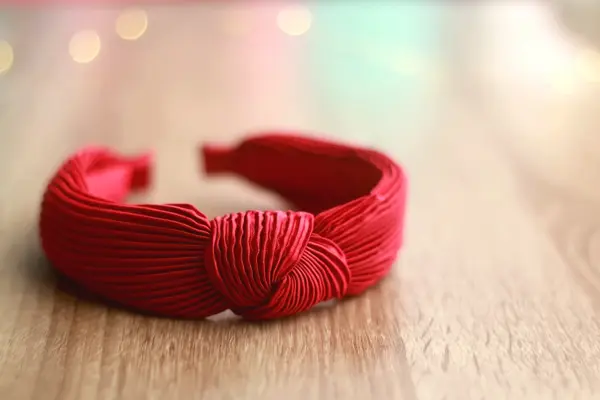 Red headband on wooden background. Selective focus.
