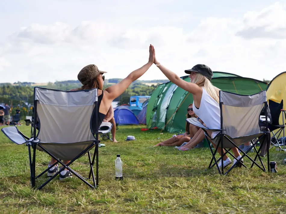 Rearview shot of two friends giving each other a high five at while sitting in camping chairshttp://195.154.178.81/DATA/shoots/ic_782680.jpg