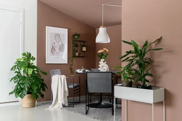 Stue med brun vegg og grønnplanter med en sittegruppe i et hjørne