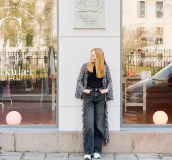 Dame poserer utenfor bruktbutikk i Oslo