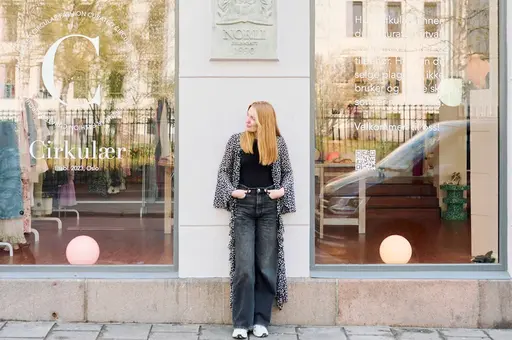 Dame poserer utenfor bruktbutikk i Oslo