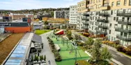 Thon Senter Triaden fasade, med lekeplass og uteservering.