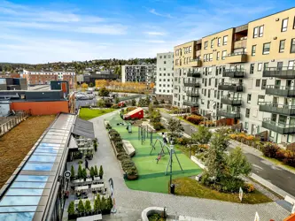 Thon Senter Triaden fasade, med lekeplass og uteservering.