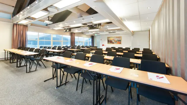 Kurs og konferanserom med TV, langbord og stoler hos Thon Hotel Sandnes