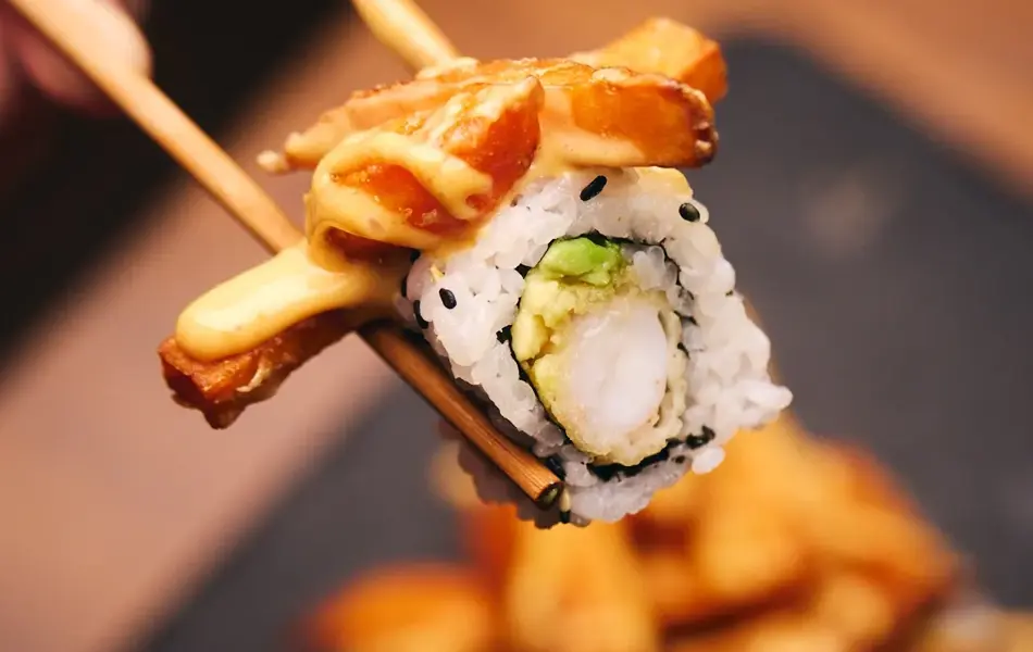 hånd som holder spisepinner med sushi fra sumo