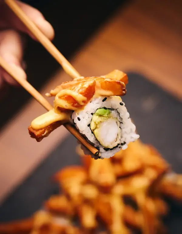 hånd som holder spisepinner med sushi fra sumo