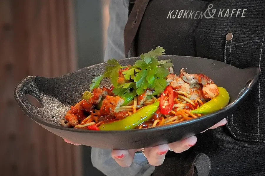 hånd som holder fat med mat