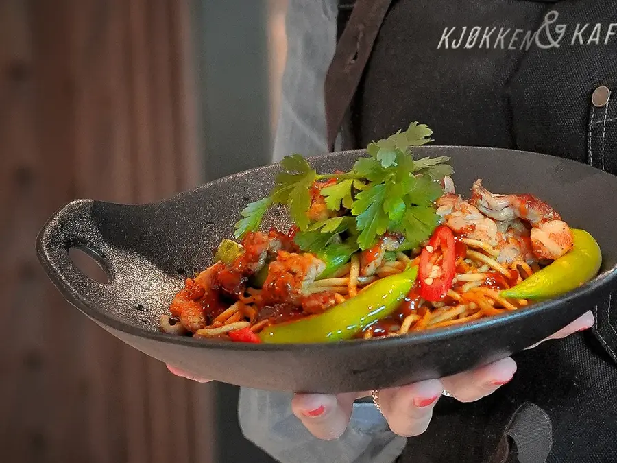 hånd som holder fat med mat