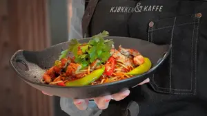 hånd som holder fat med mat