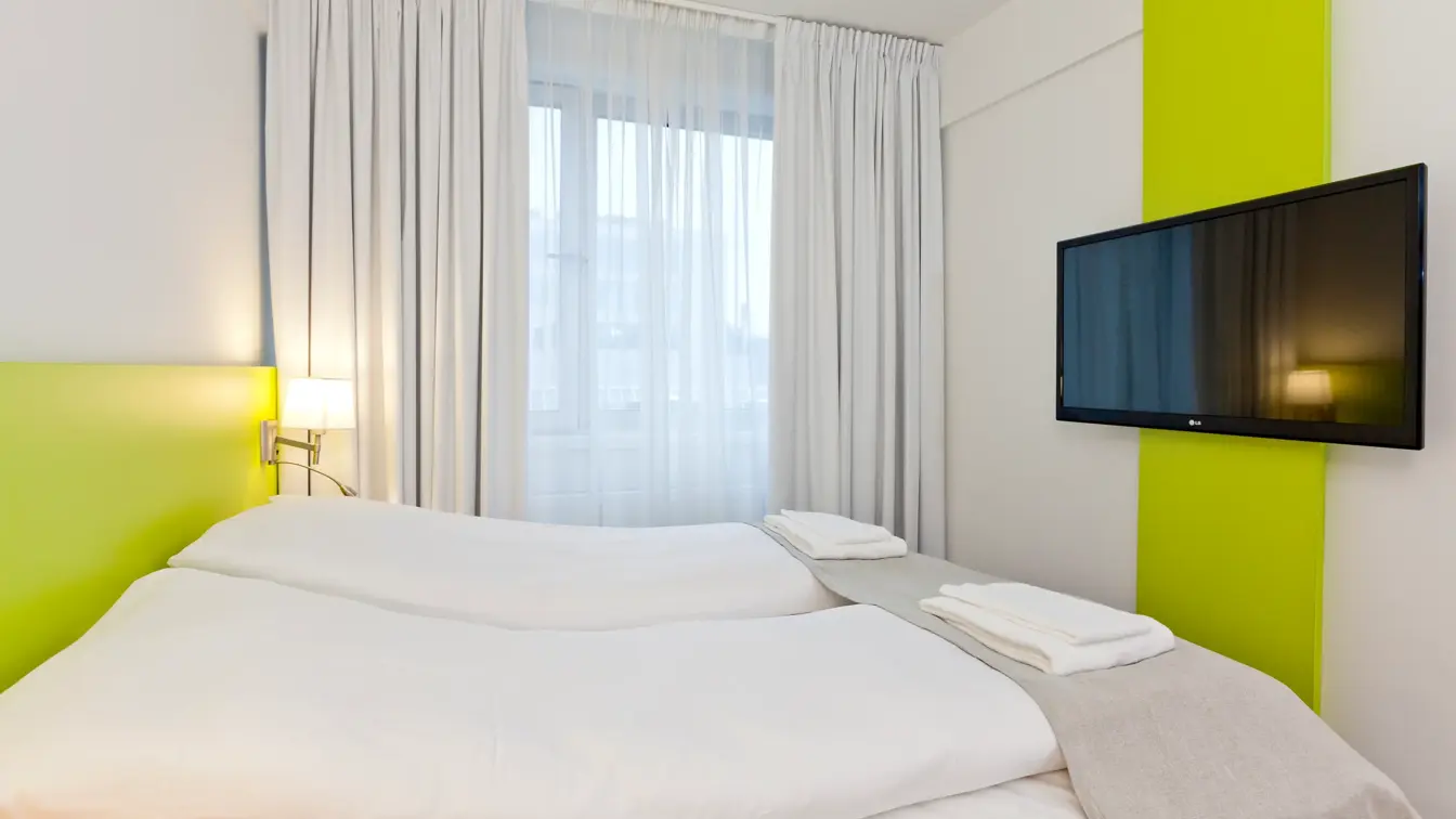 Seng og TV i dobbeltrom på Thon Hotel Munch