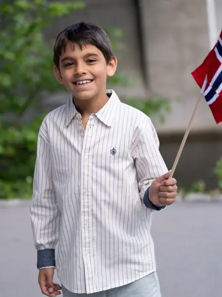 Gutt i stripete skjorte og shorts