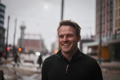 Bilde av Lars Eikeland Hagen i Oslo Sentrum. Han smiler mot kameraet. 