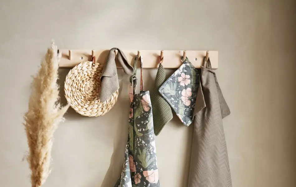 blomstret kjøkkenforkle, grytekluter og diverse kjøkkenutstyr