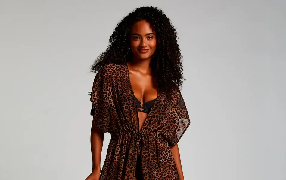 Modell med sort bikini og en lang leopardmønstret kaftan.