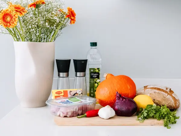 Ingredienser til gresskarsuppe på kjøkkenbenk