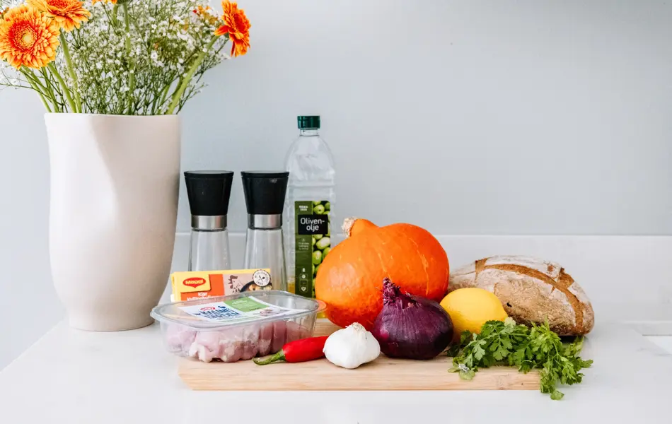 Ingredienser til gresskarsuppe på kjøkkenbenk