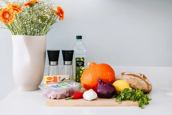 Ingredienser til gresskarsuppe på kjøkkenbenk