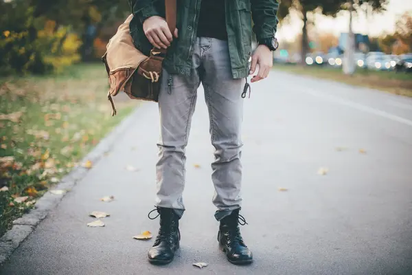 Halvprofil av mann med olabukse og svarte combat boots 