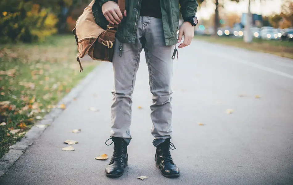 Halvprofil av mann med olabukse og svarte combat boots 