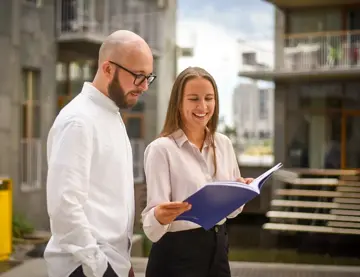Anders Nandrup Rylander og Kaia Elnæs Jenssen leser bærekraftrapporten sammen