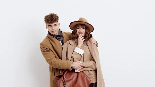 mann og dame poserer i brun og beige kåpe