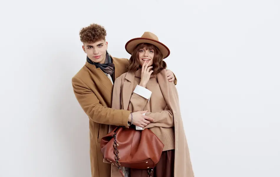 mann og dame poserer i brun og beige kåpe