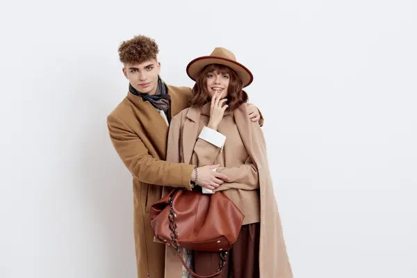 mann og dame poserer i brun og beige kåpe