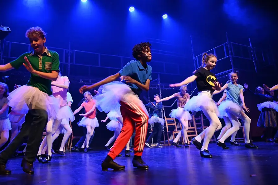 Barn og tenåringer som danser med på scene