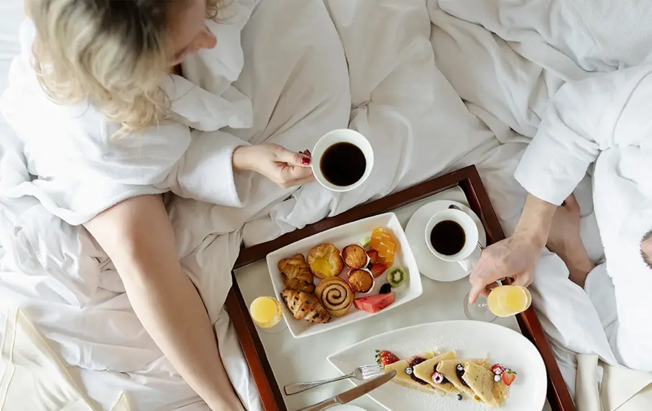 kjærestepar har frokost i senga