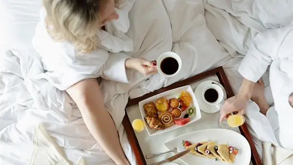 kjærestepar har frokost i senga
