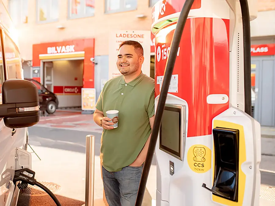 mann som fyller på drivstoff til en hvit varebil