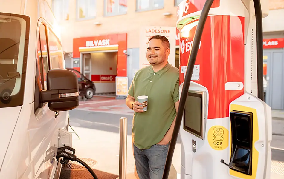 mann som fyller på drivstoff til en hvit varebil