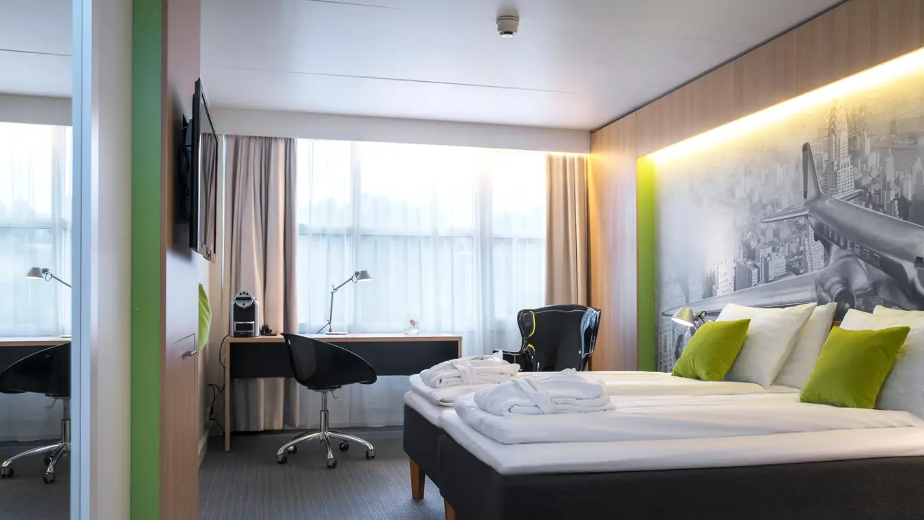 Dobbeltseng og skrivebord i superior room på Thon Hotel Bergen Airport