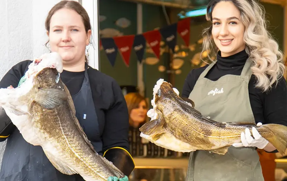 To jenter holder hver sin fisk