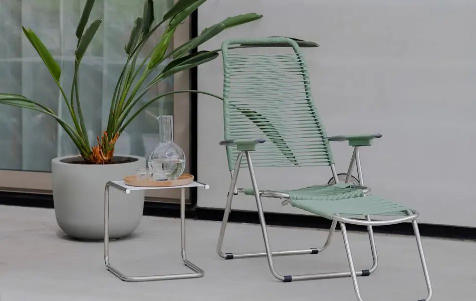 Grønn spagetti stol med en grønn plante